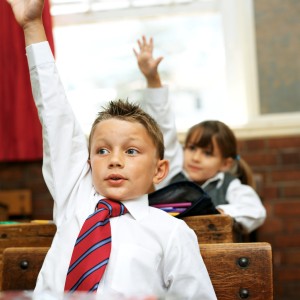 Young Boy at School Raising His Hand to Answer in Class